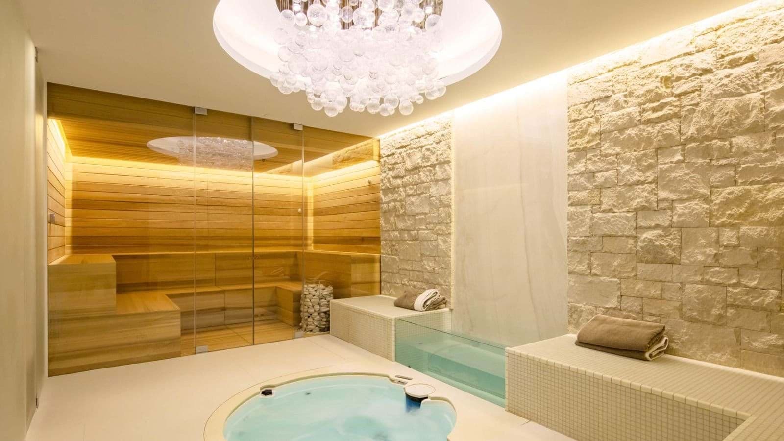 Spa room with cedar sauna, hot tub, and stone feature wall