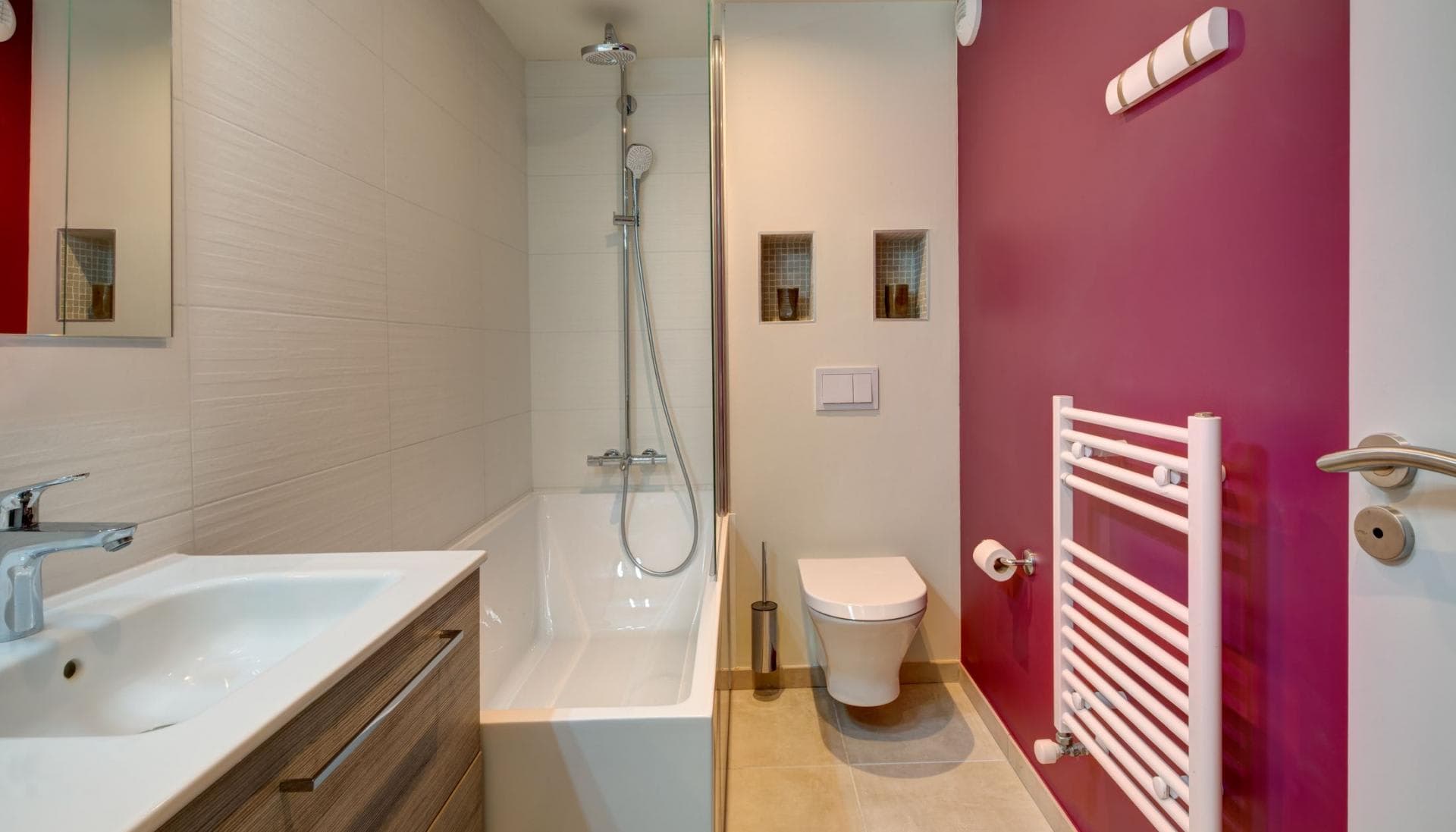 Bathroom with soaking tub, rainfall shower, and heated towel rack