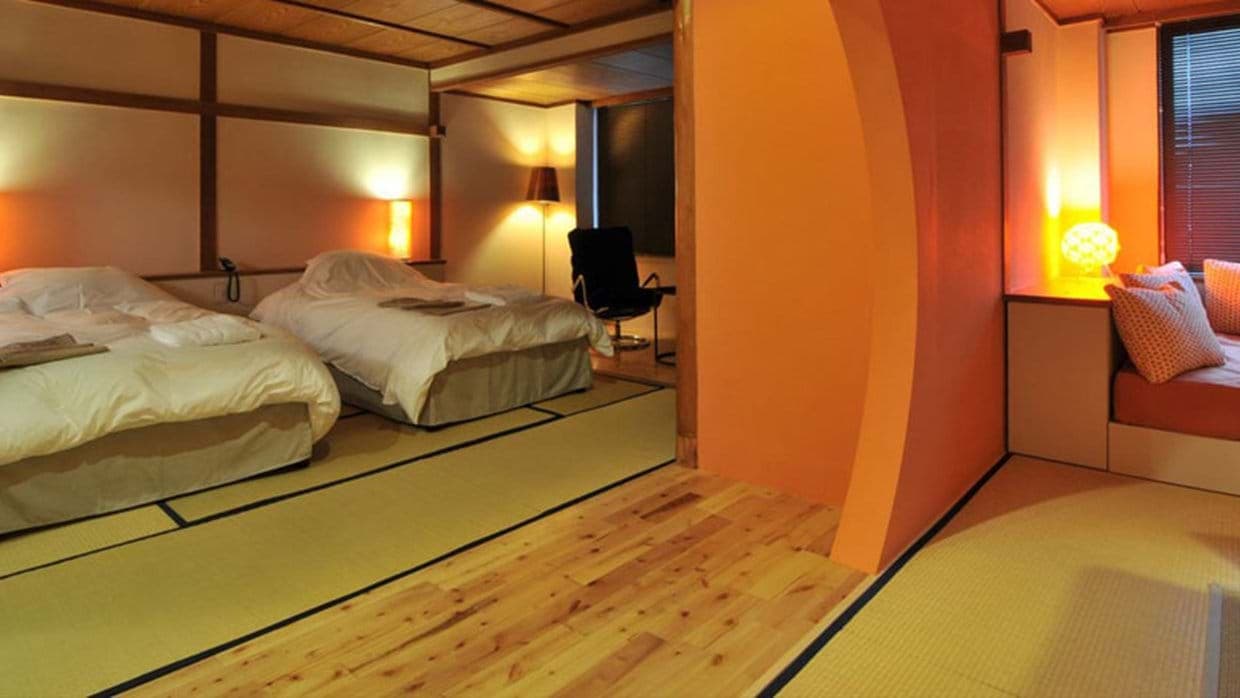 Japanese-style bedroom with twin beds on tatami mats and separate seating area