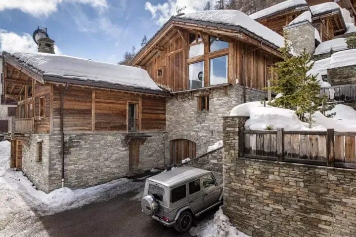 Stone and timber chalet exterior with private driveway parking