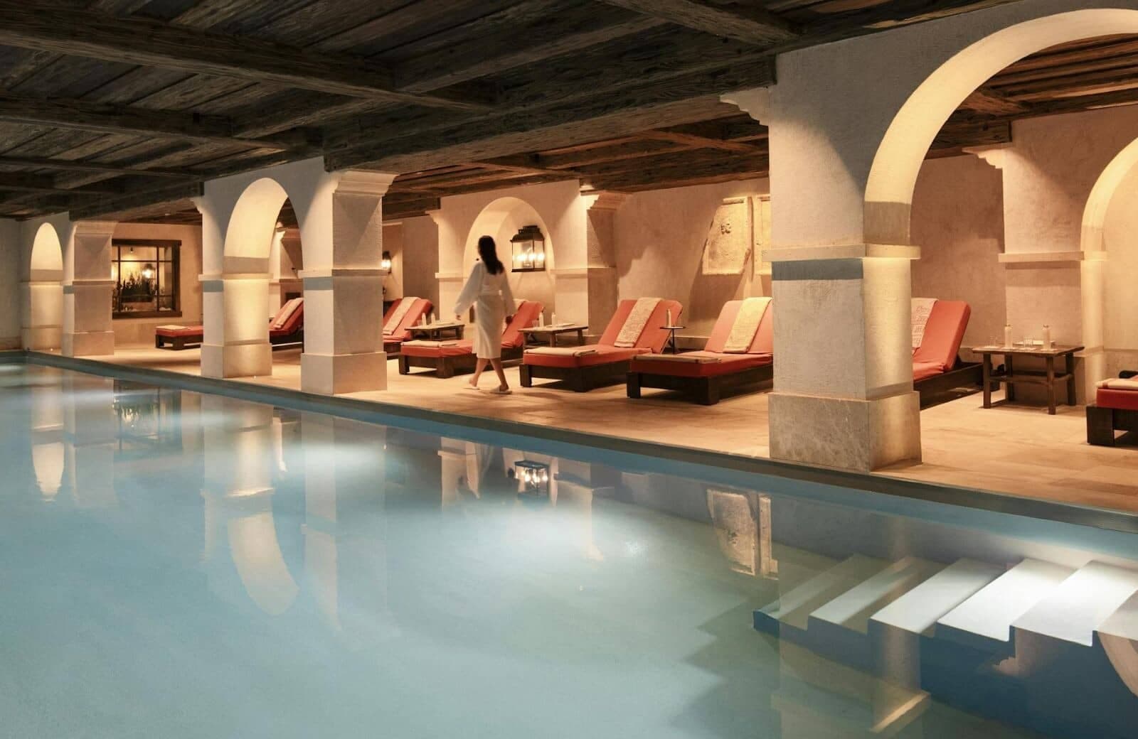 Indoor pool with timber-beamed ceiling; poolside seating for 10