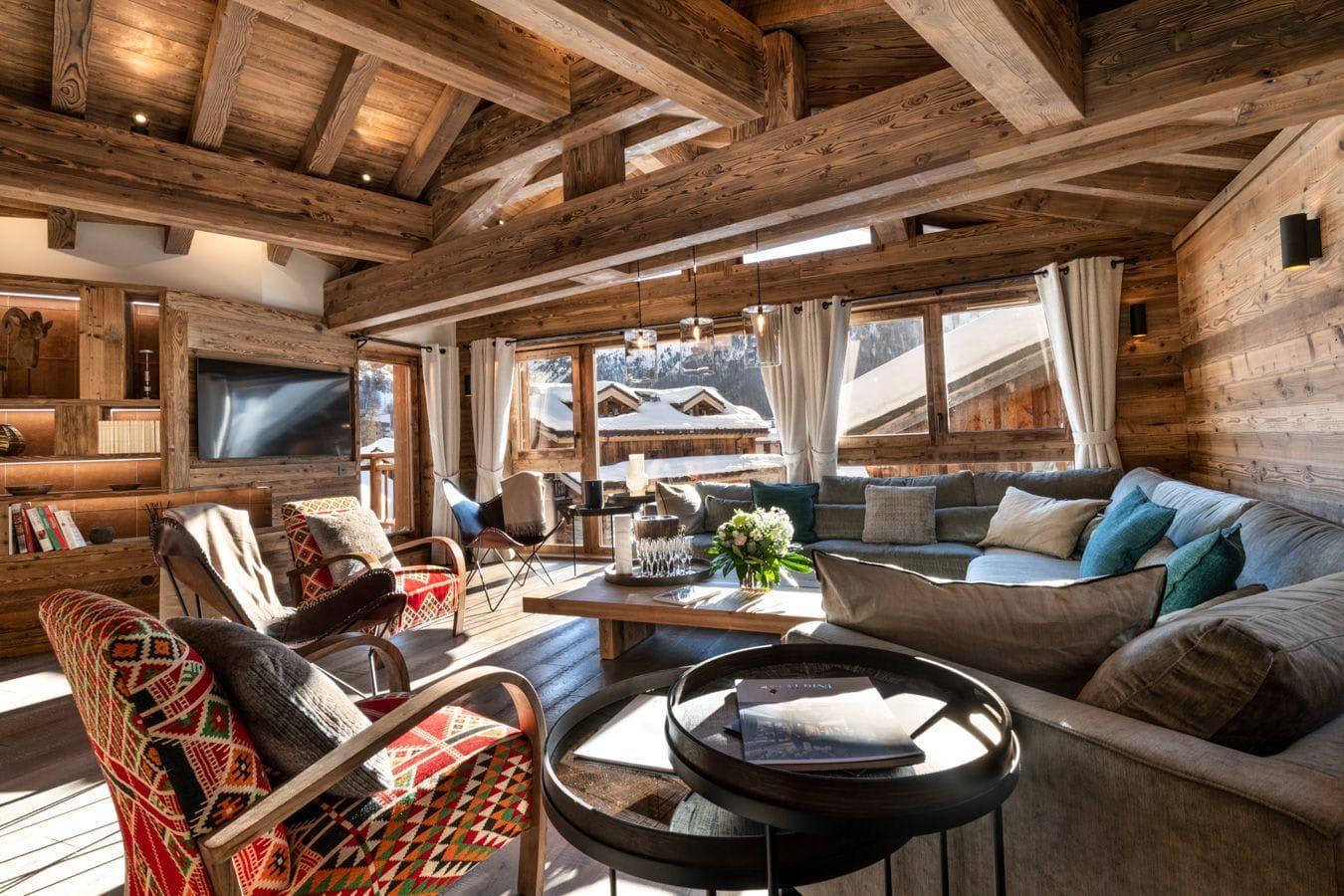 Living room with vaulted timber ceiling and seating for 10; village views