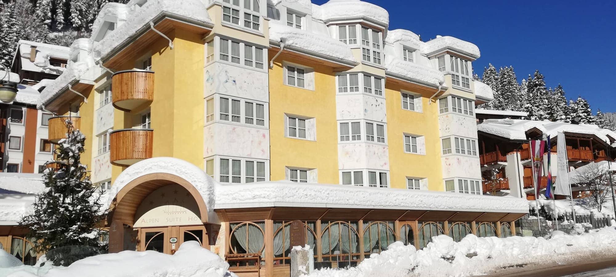 Hotel exterior with private balconies and glass-enclosed dining porch