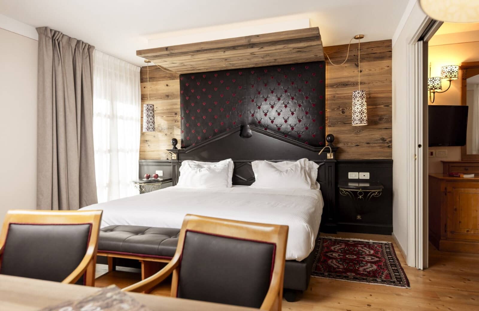 Primary bedroom with king bed, reclaimed wood walls, and integrated reading lights