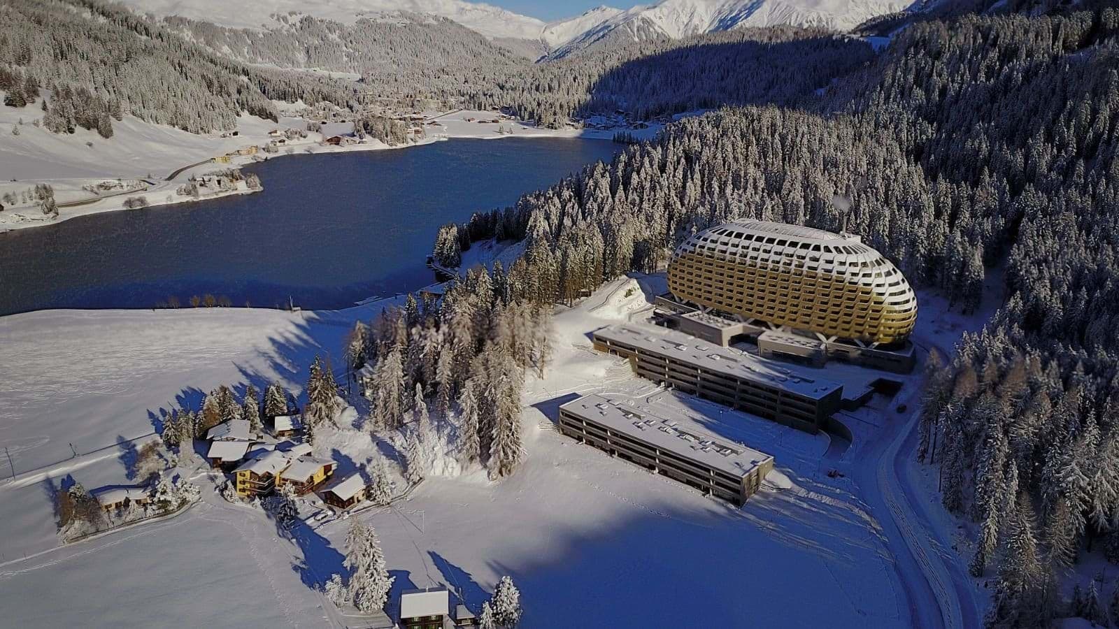 Aerial view of property with lake access and mountain backdrop