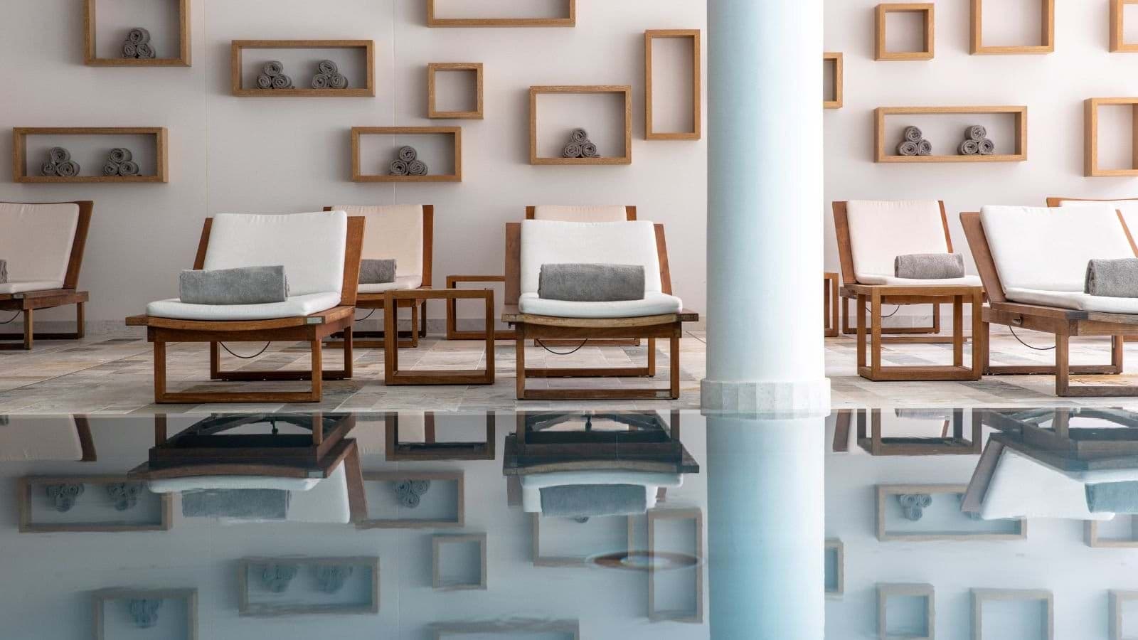 Indoor pool area with poolside loungers and complimentary towel service