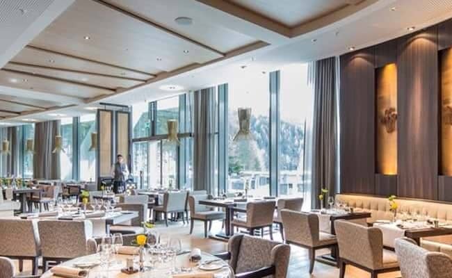 Hotel restaurant with floor-to-ceiling windows and forest views