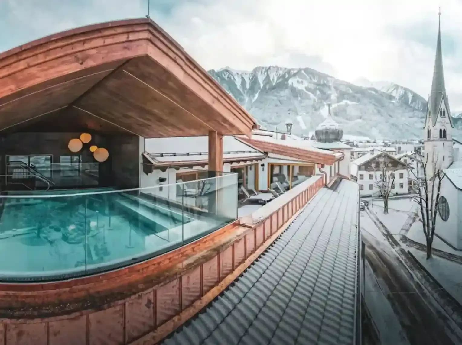 Rooftop heated pool with mountain and village church views