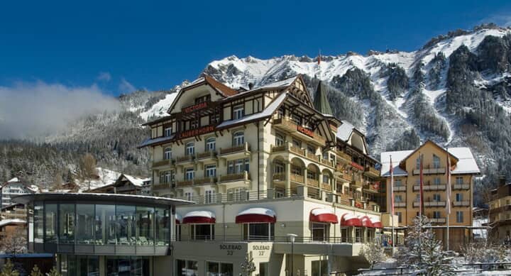 Hotel exterior with heated saltwater pool and Swiss Alps backdrop