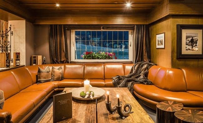 Lounge area with leather wrap-around seating and window views of ski slopes