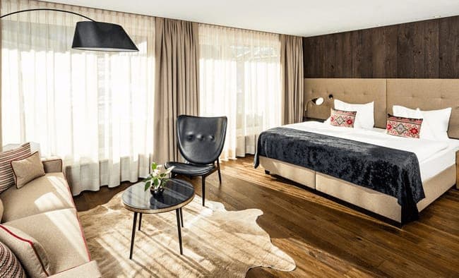 Primary bedroom with king bed, seating area, and hardwood floors