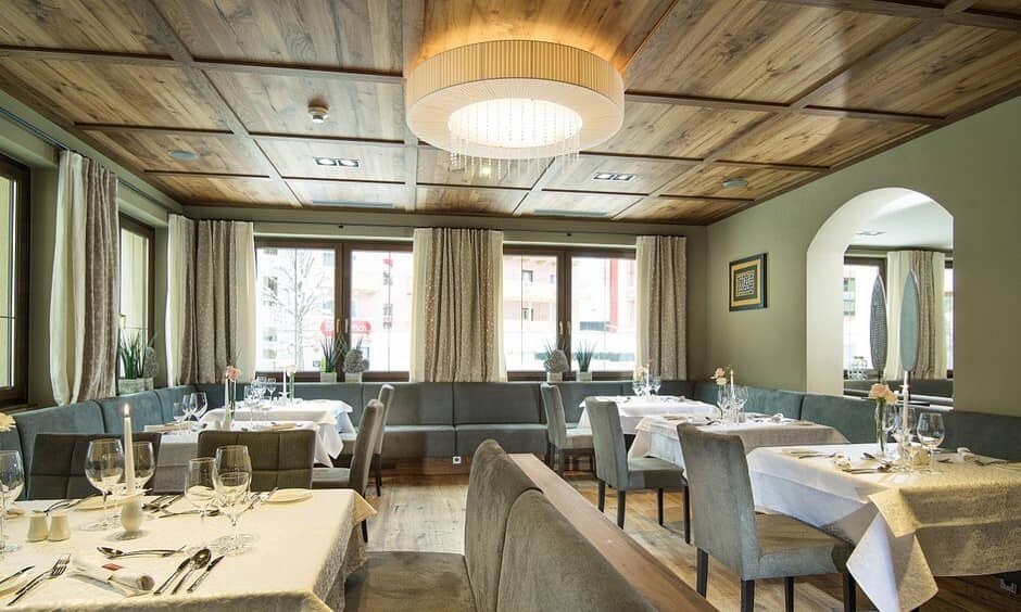 Dining room with wood-paneled ceiling and perimeter banquette seating