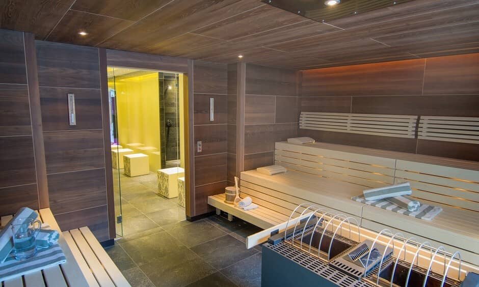 Sauna with tiered seating and adjacent glass-enclosed steam room