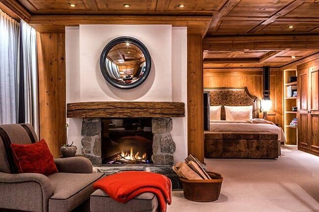 Primary suite with stone fireplace and wood-paneled ceiling