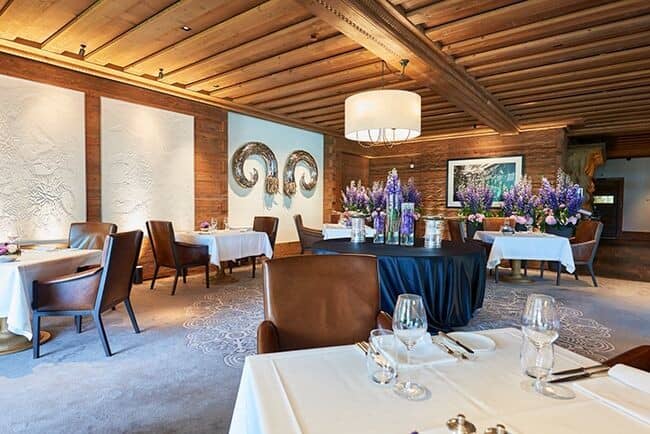 Formal dining room with wood-beamed ceilings and leather armchairs