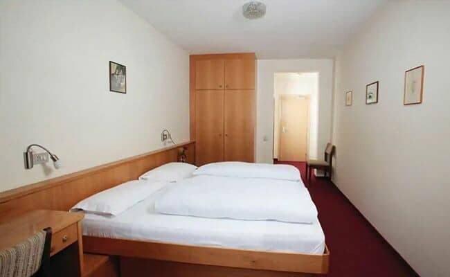 Guest bedroom with two twin beds and built-in wood wardrobe
