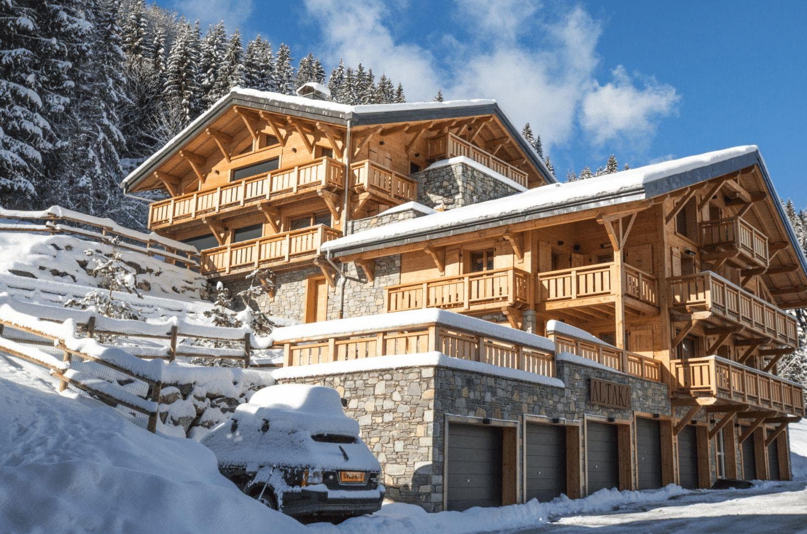 Ski-in chalet exterior with multiple balconies and private underground garage parking