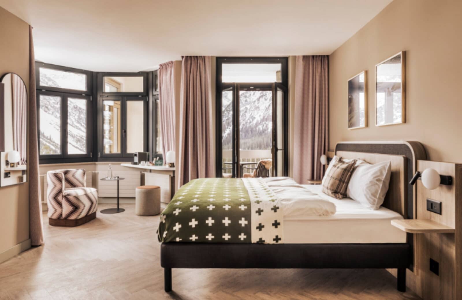 Bedroom with king bed and private balcony overlooking snow-capped mountains