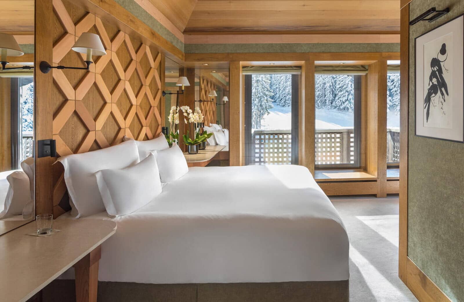 Primary bedroom with king bed, wood paneling, and snowy forest views