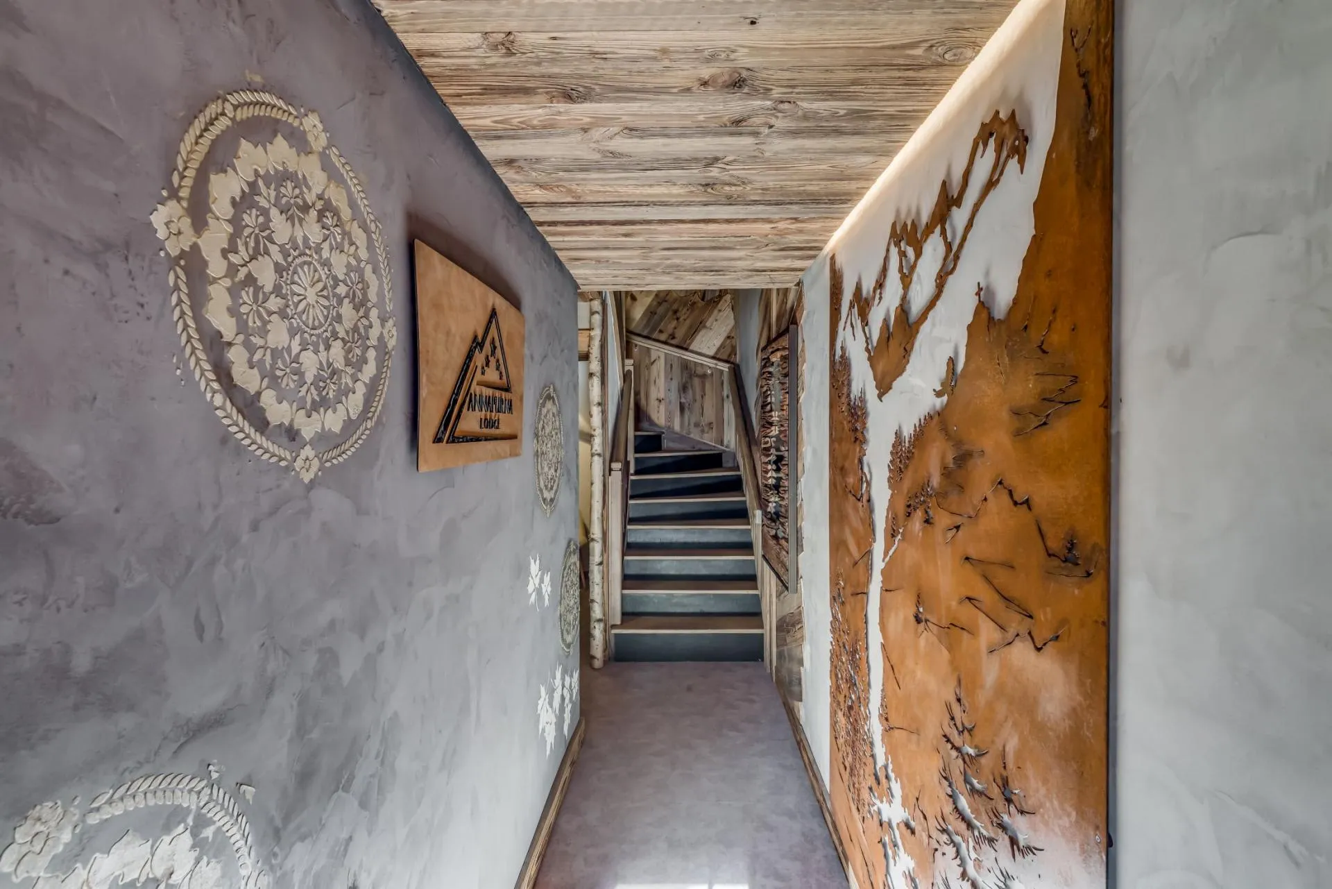 Hallway featuring custom wall murals leading to reclaimed wood staircase