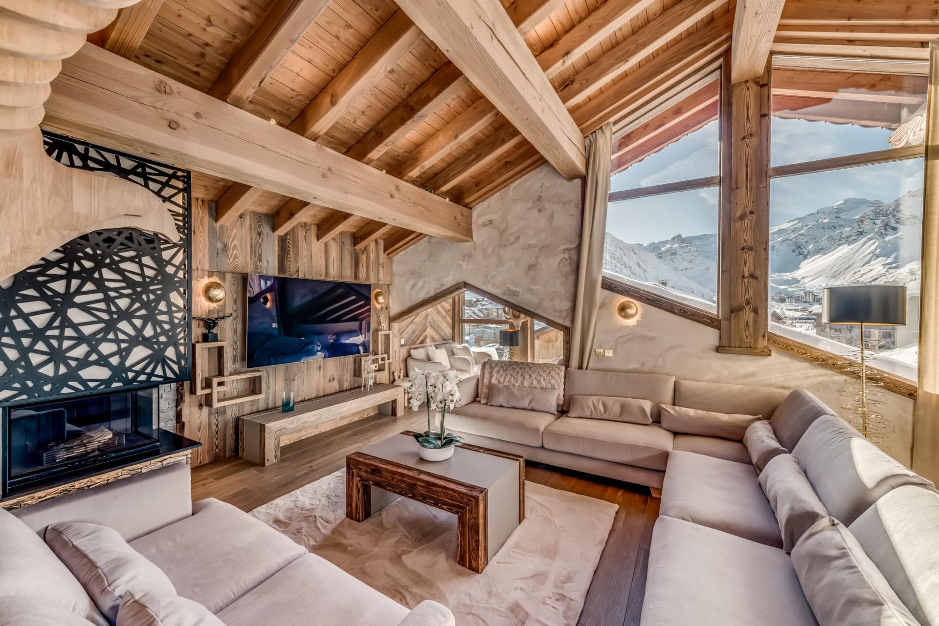Living area with wood-burning fireplace and floor-to-ceiling mountain views