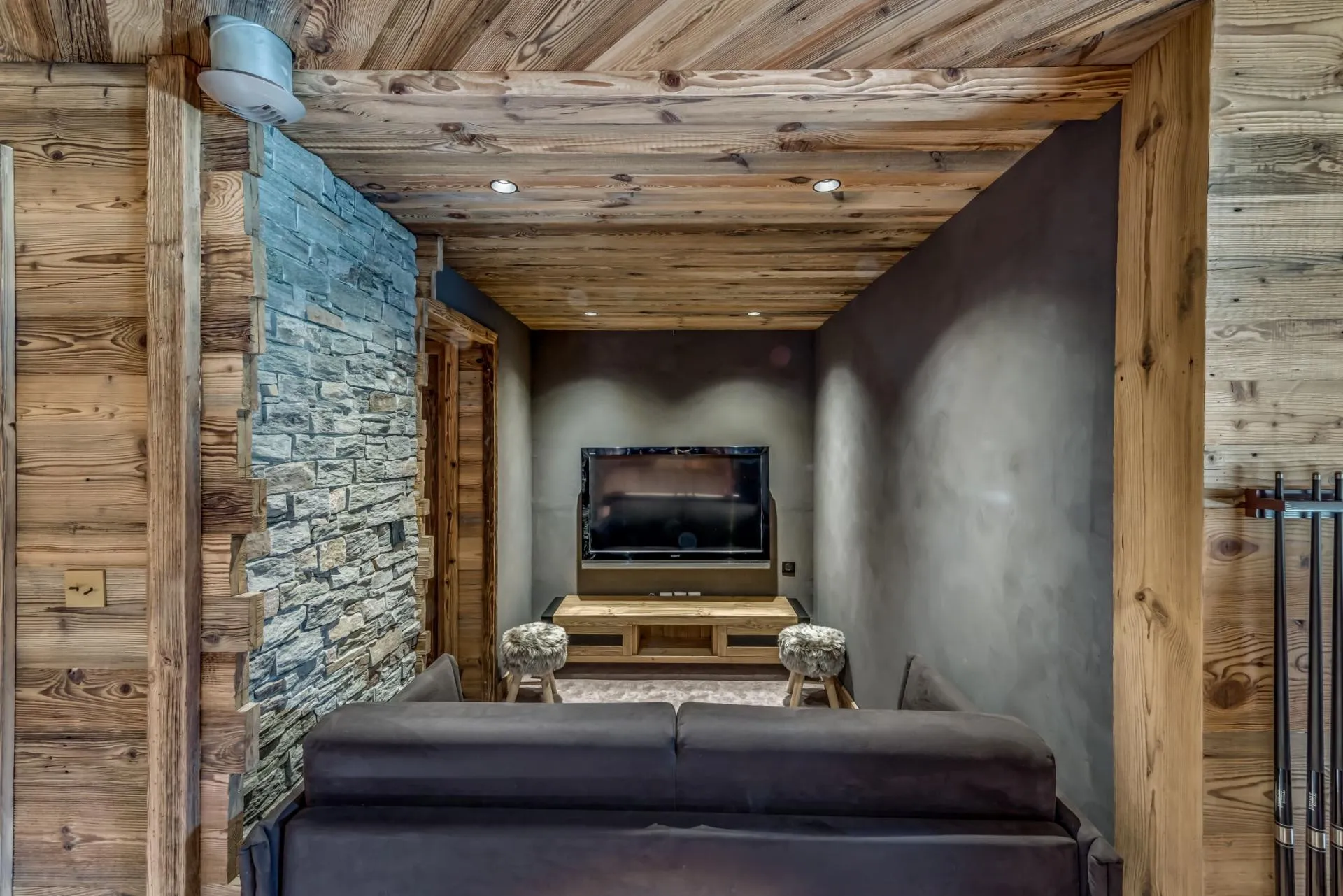 Media room with wall-mounted TV and billiard cue rack
