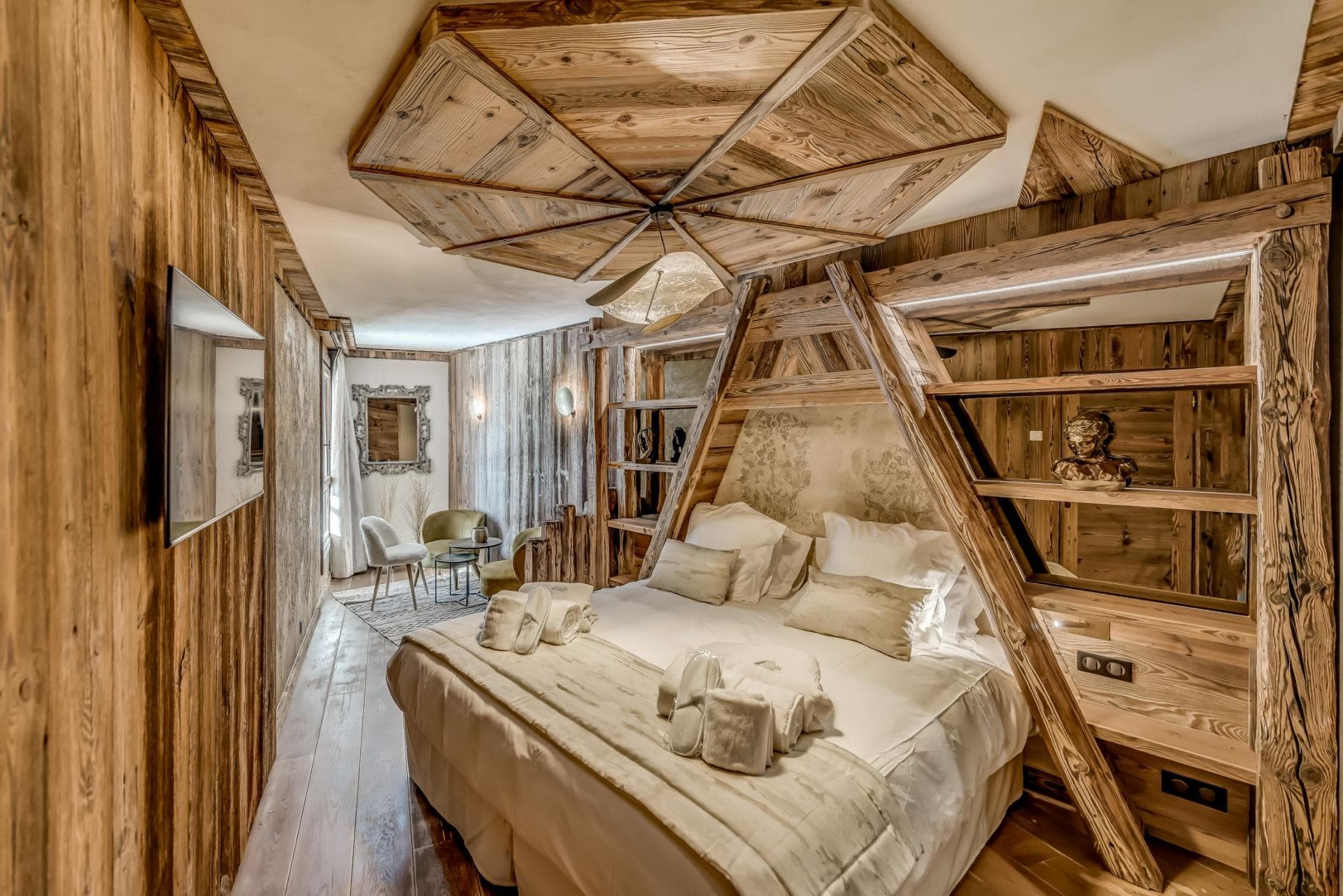 Bedroom with king bed, reclaimed wood walls, and integrated shelving