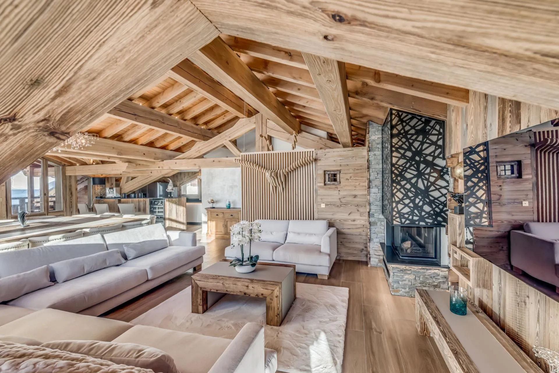 Open-plan living area with vaulted timber beams and wood-burning fireplace