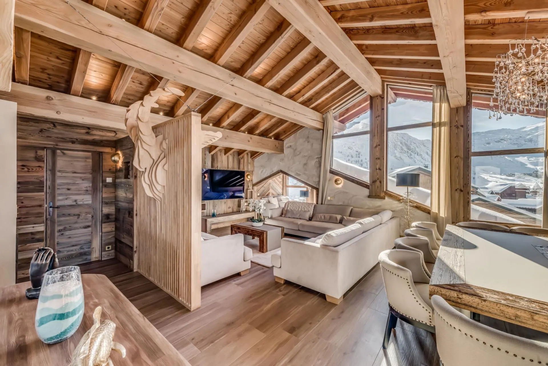 Open living and dining area with sectional seating and alpine mountain views