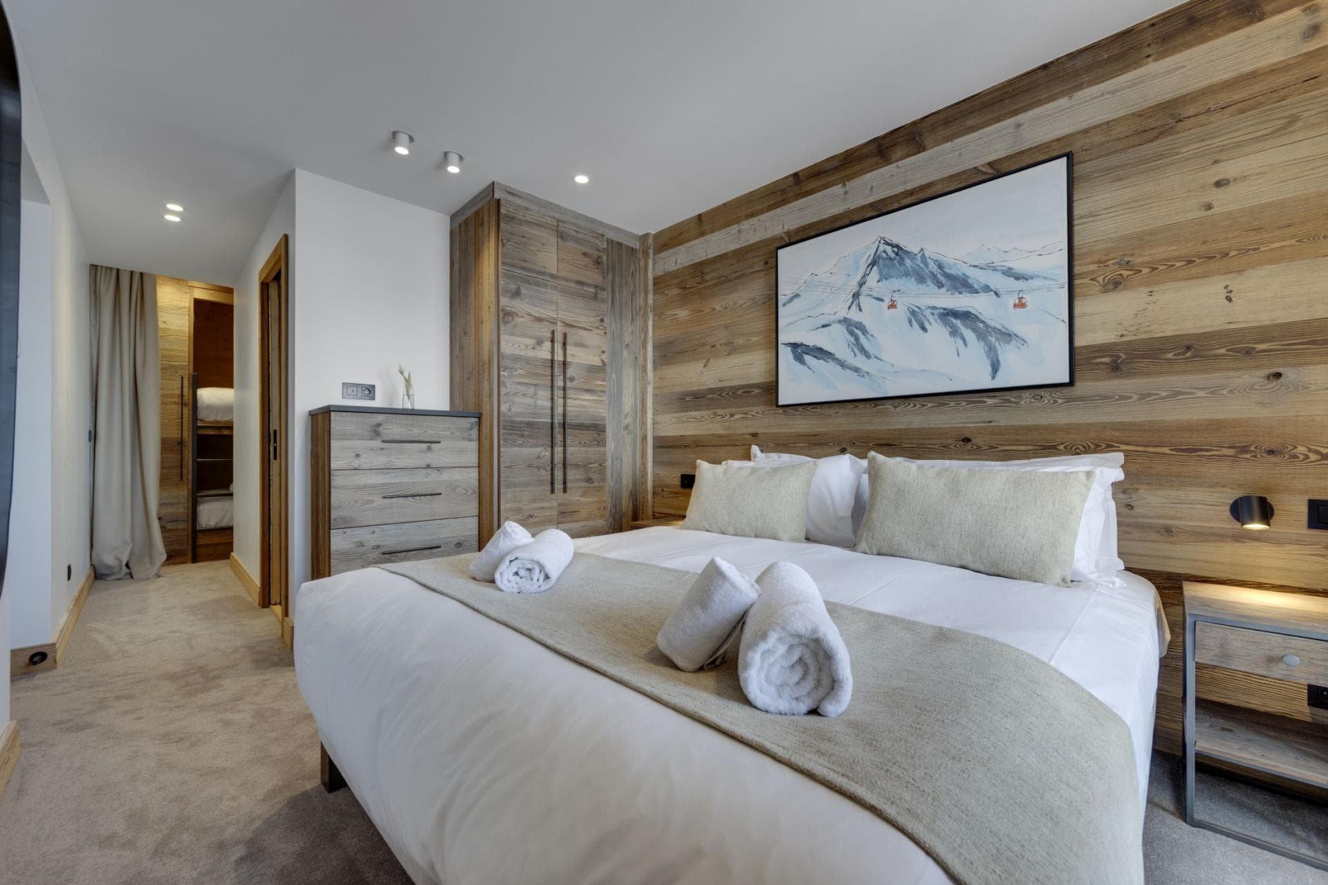 Primary bedroom with king bed, reclaimed wood walls, and ensuite access