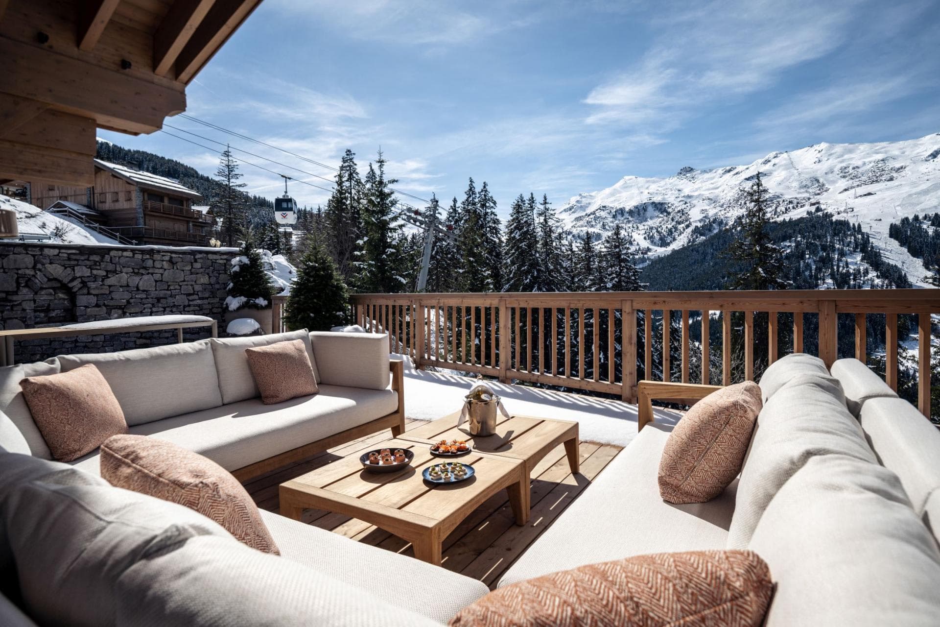 Deck with lounge seating and views of the mountains and ski gondola