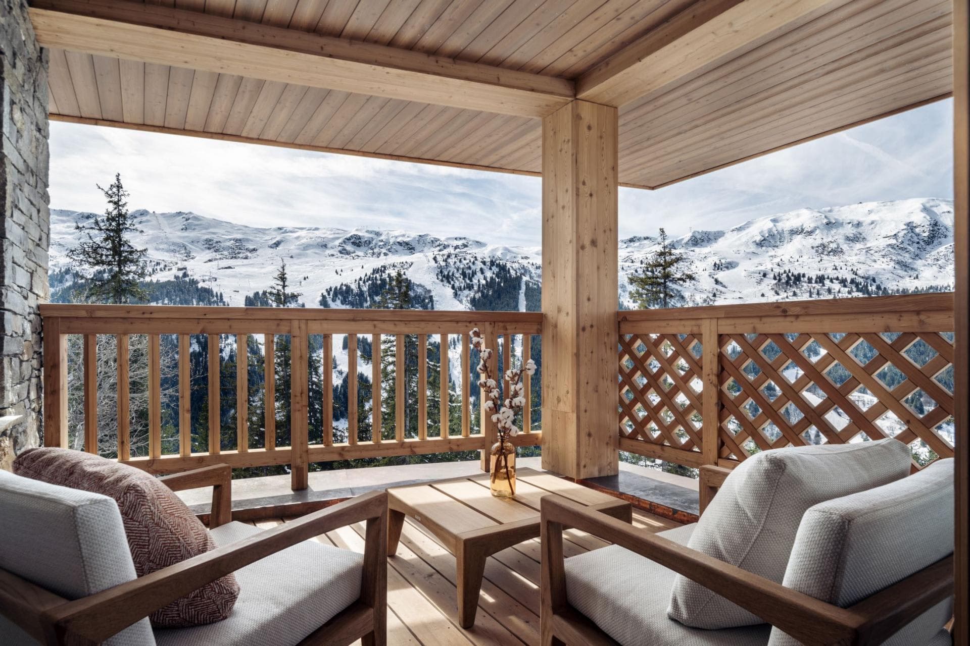 Covered balcony with armchair seating and panoramic mountain views