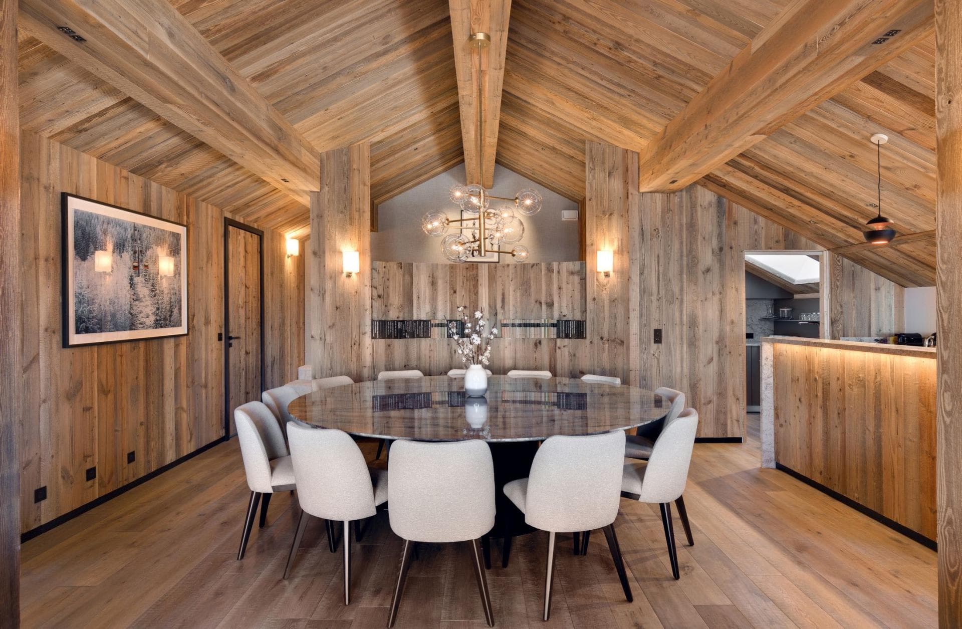 Dining area with round stone table for 10 and vaulted wood ceilings