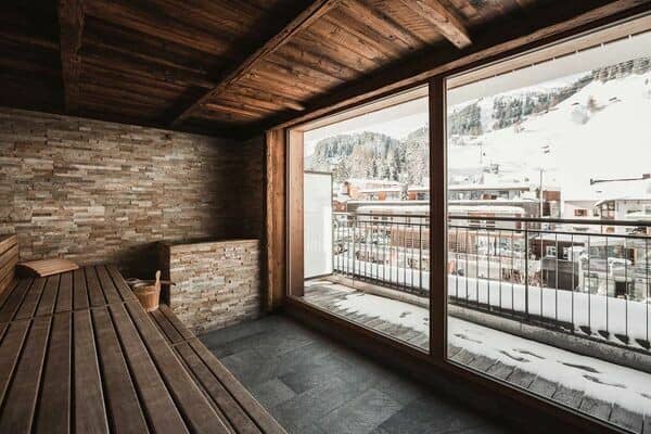 Private sauna with stone accents and floor-to-ceiling mountain views