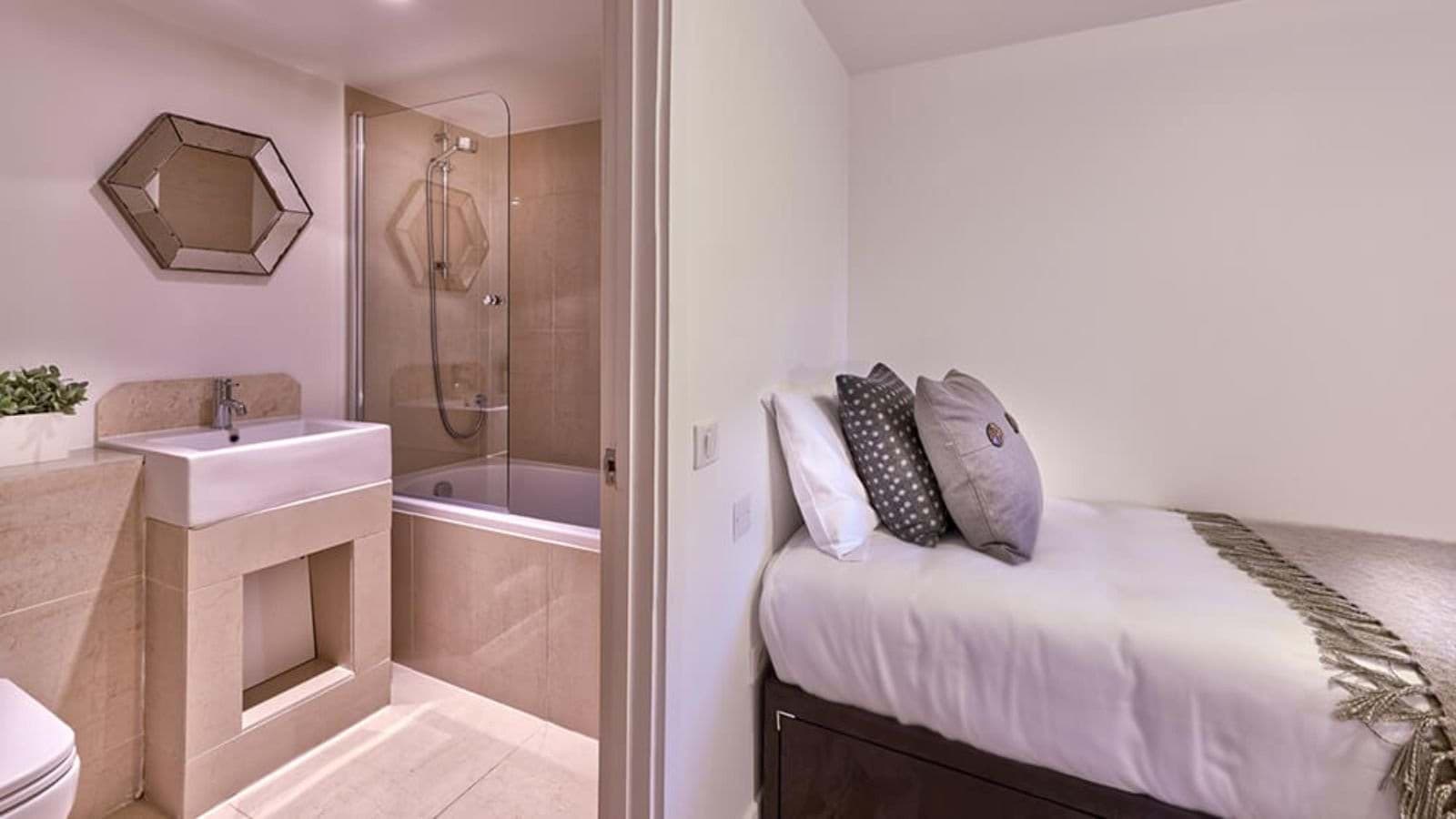 Guest bedroom with twin bed and attached ensuite bathroom featuring a soaking tub