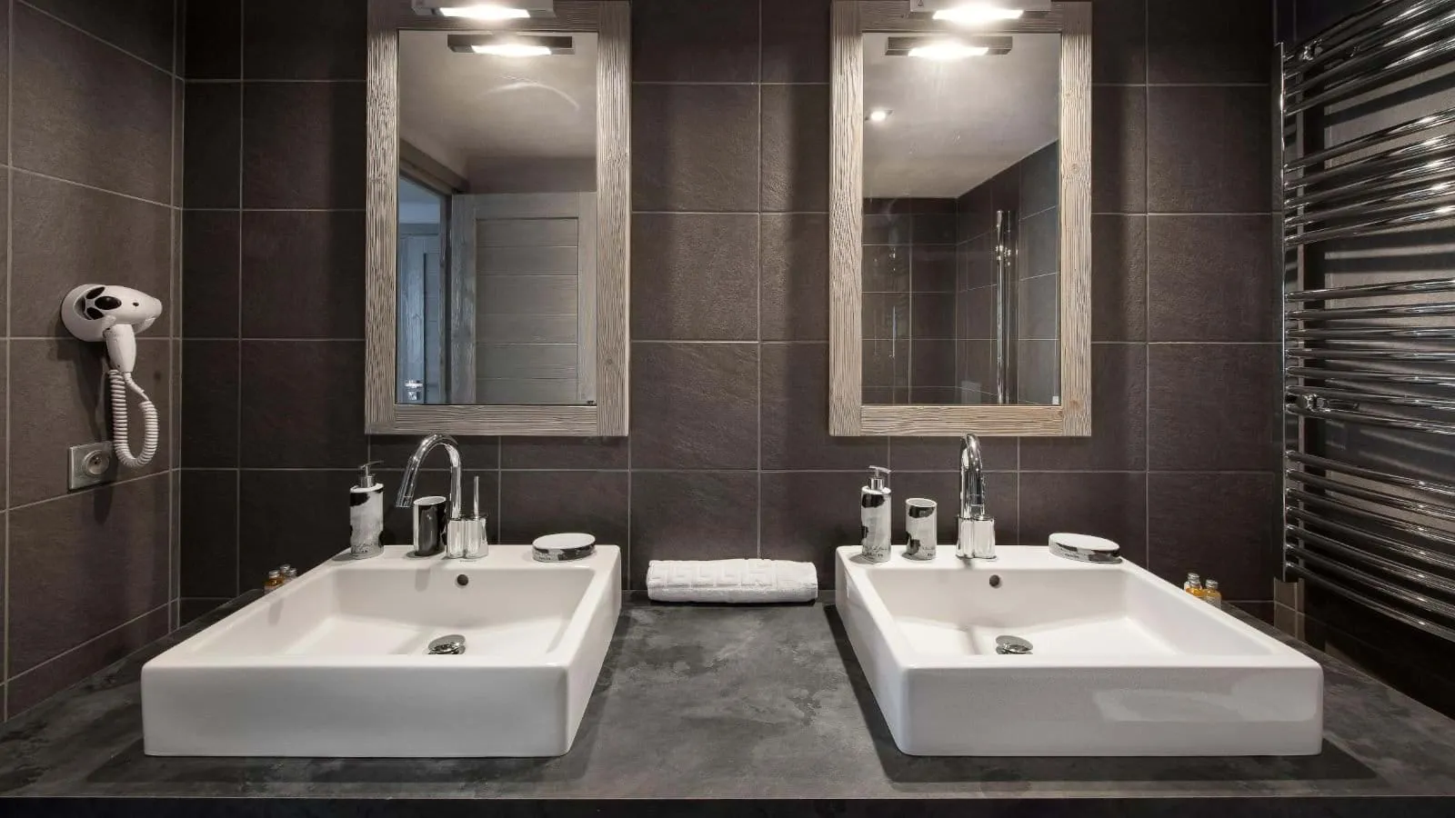 En-suite bathroom with twin basins and a heated towel rail