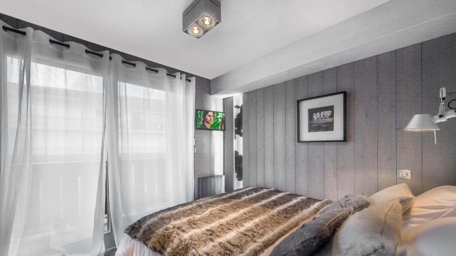 Double bedroom with balcony access and a wall-mounted television