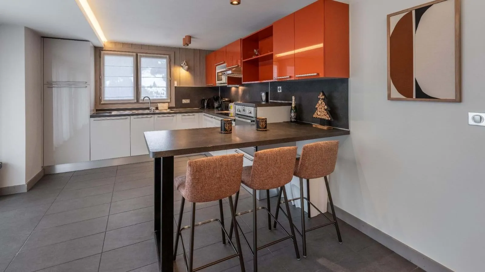 Open kitchen with integrated appliances and breakfast-bar seating