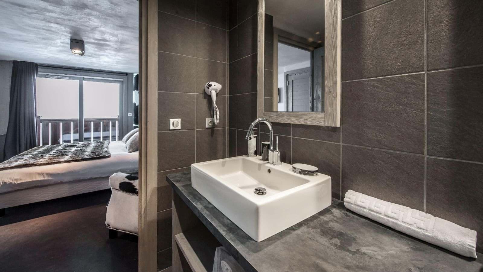 En suite bathroom with vessel sink and wall-mounted hairdryer
