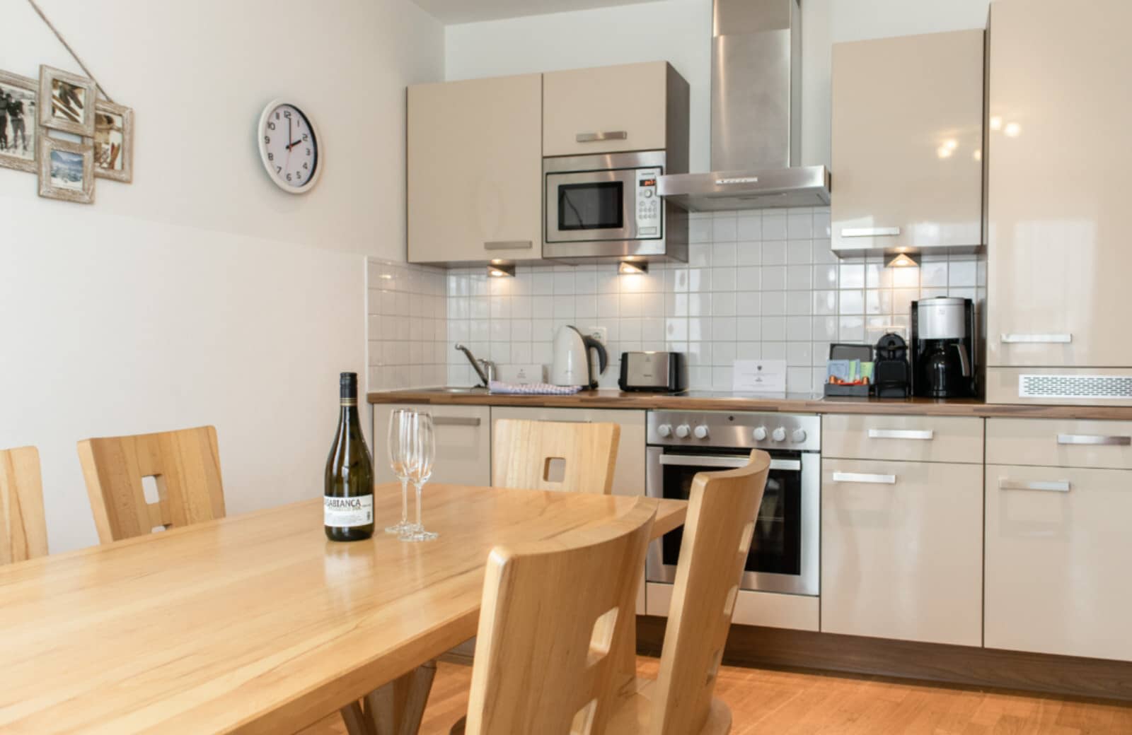 Kitchen with Nespresso machine, electric stove, and dining seating for 4