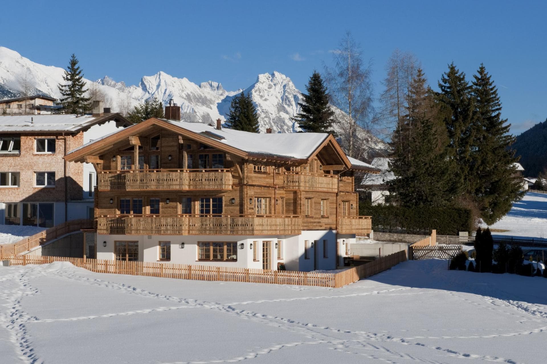 Chalet exterior with wrap-around balconies and alpine mountain views