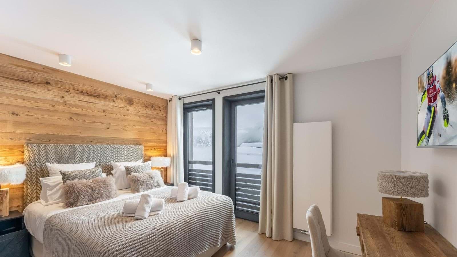 Bedroom with king bed, workspace desk, and balcony access