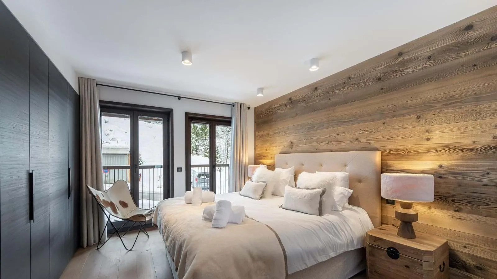 Master double bedroom with a timber feature wall and balcony access