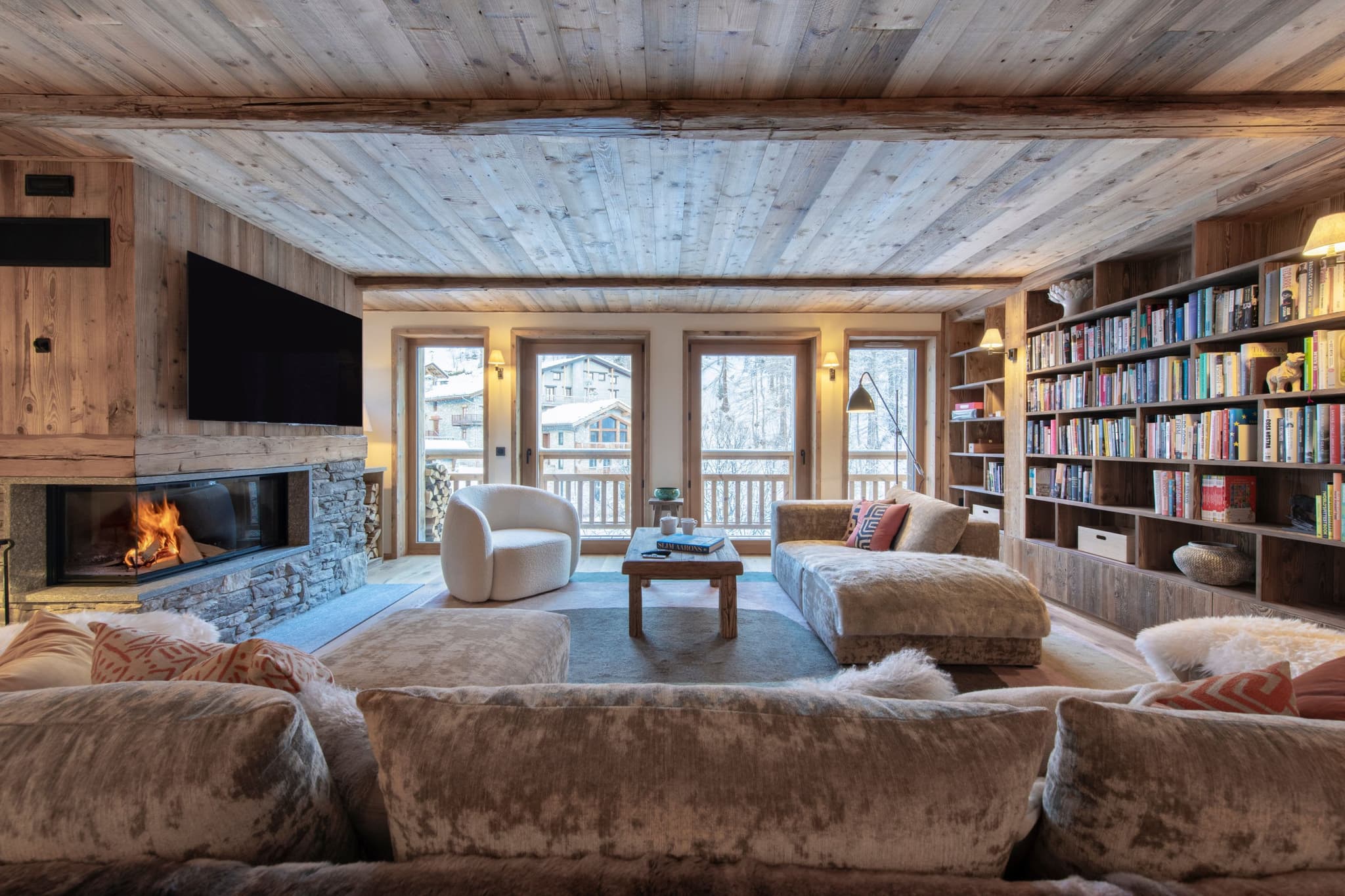 Living area with wood-burning fireplace and floor-to-ceiling library wall