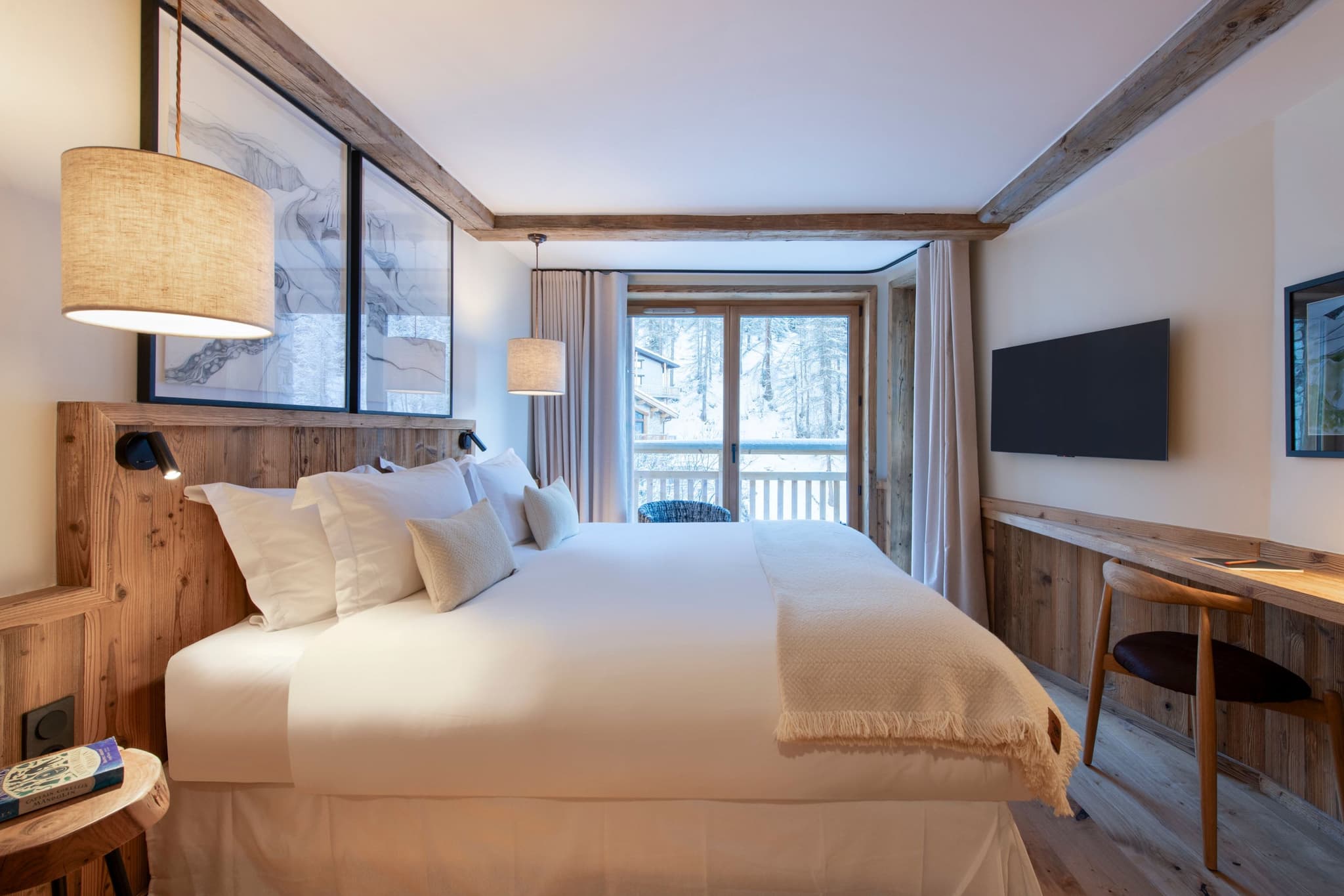 Bedroom with king bed, wall-mounted TV, and private balcony access