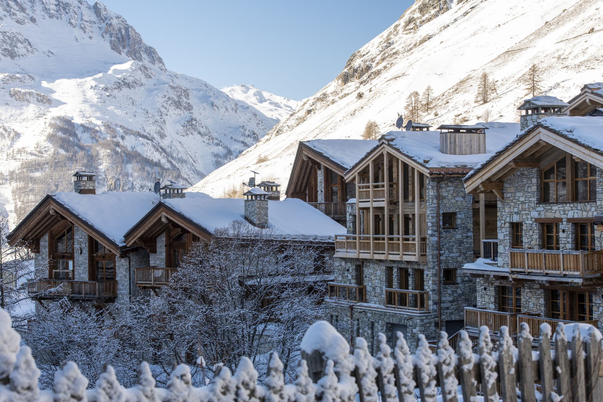 Stone-clad chalets with private balconies and mountain valley views