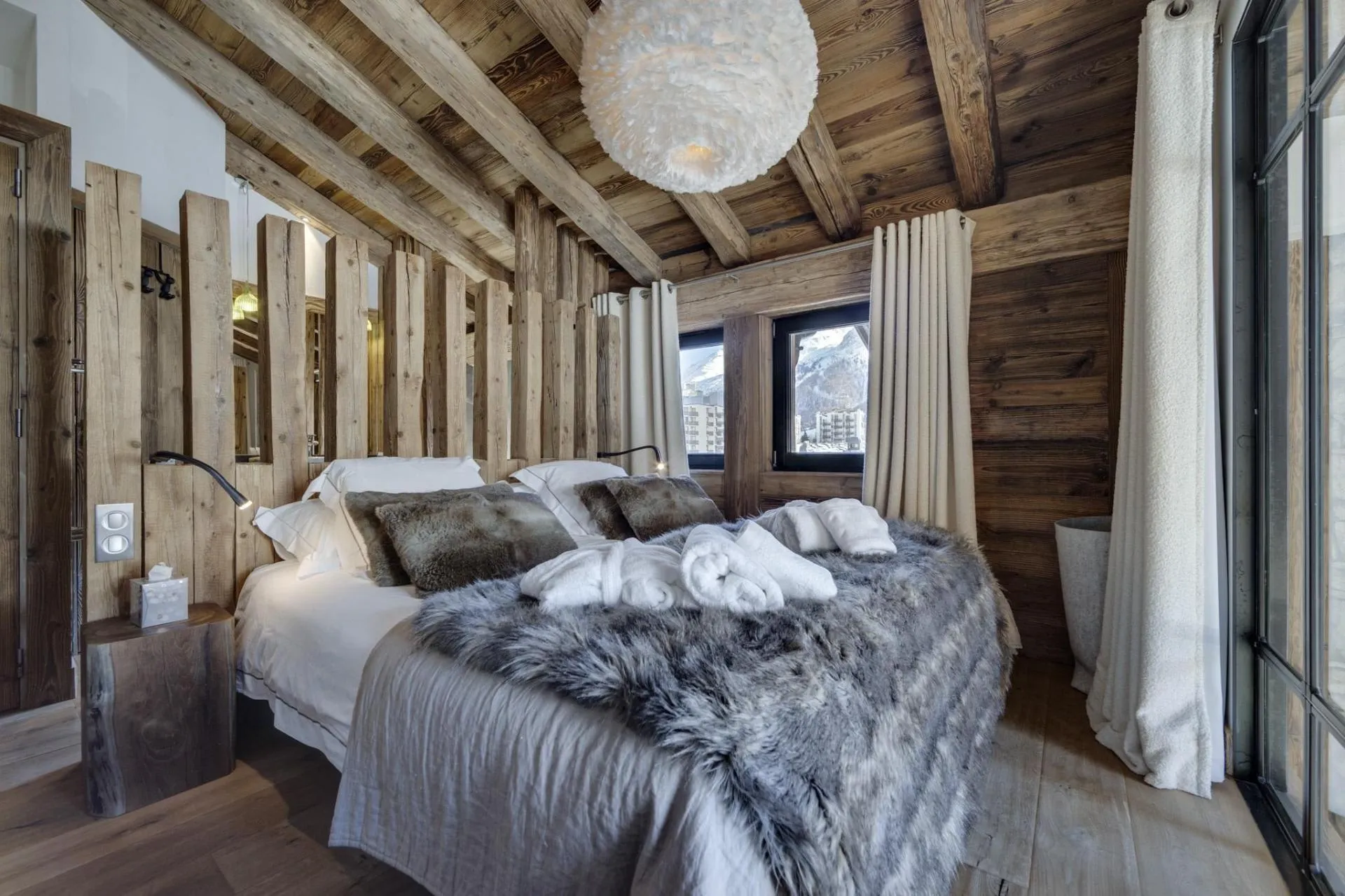Double bedroom with timber beams and mountain views