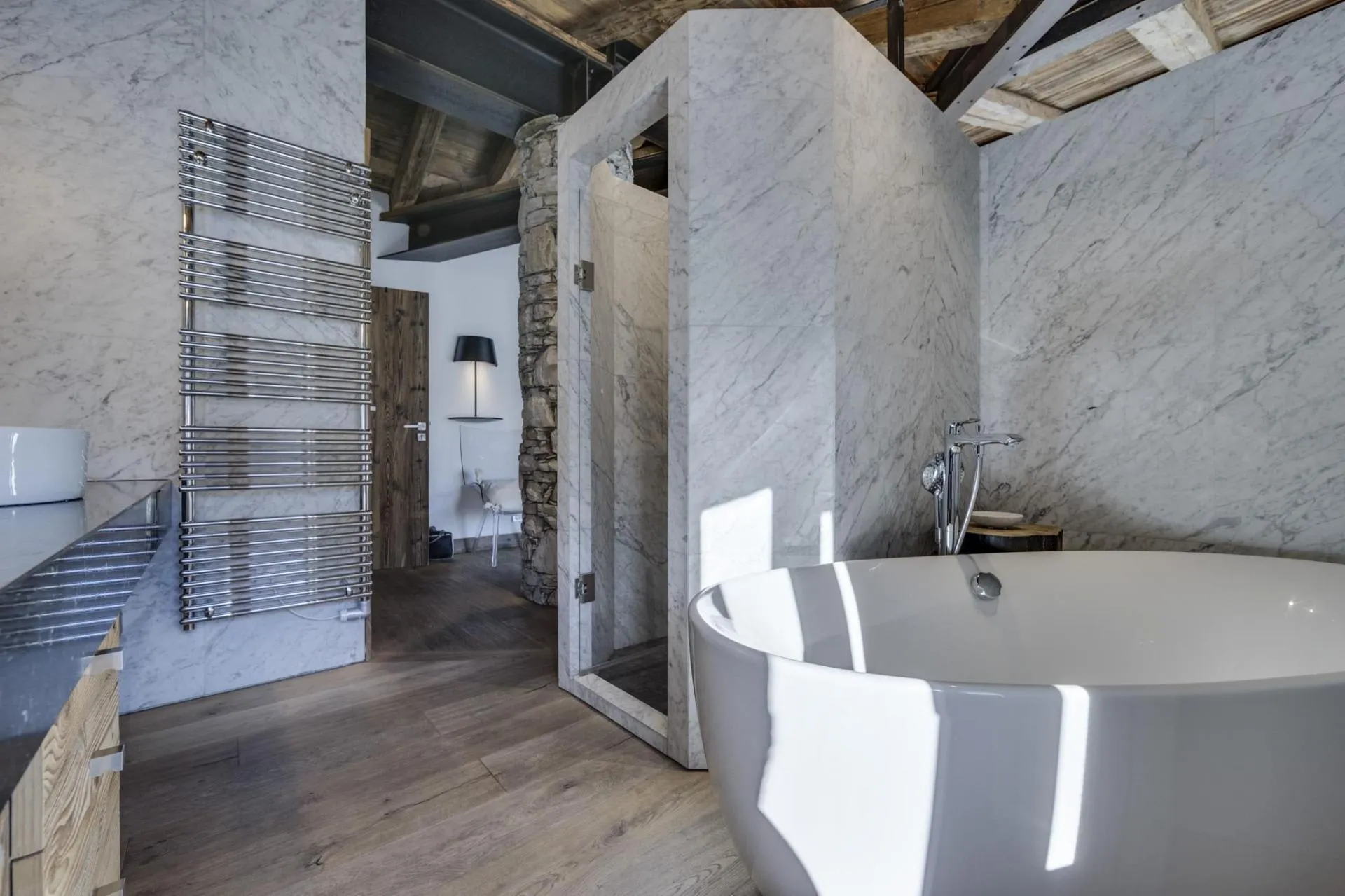 Bathroom with soaking tub, marble walk-in shower, and heated towel rack