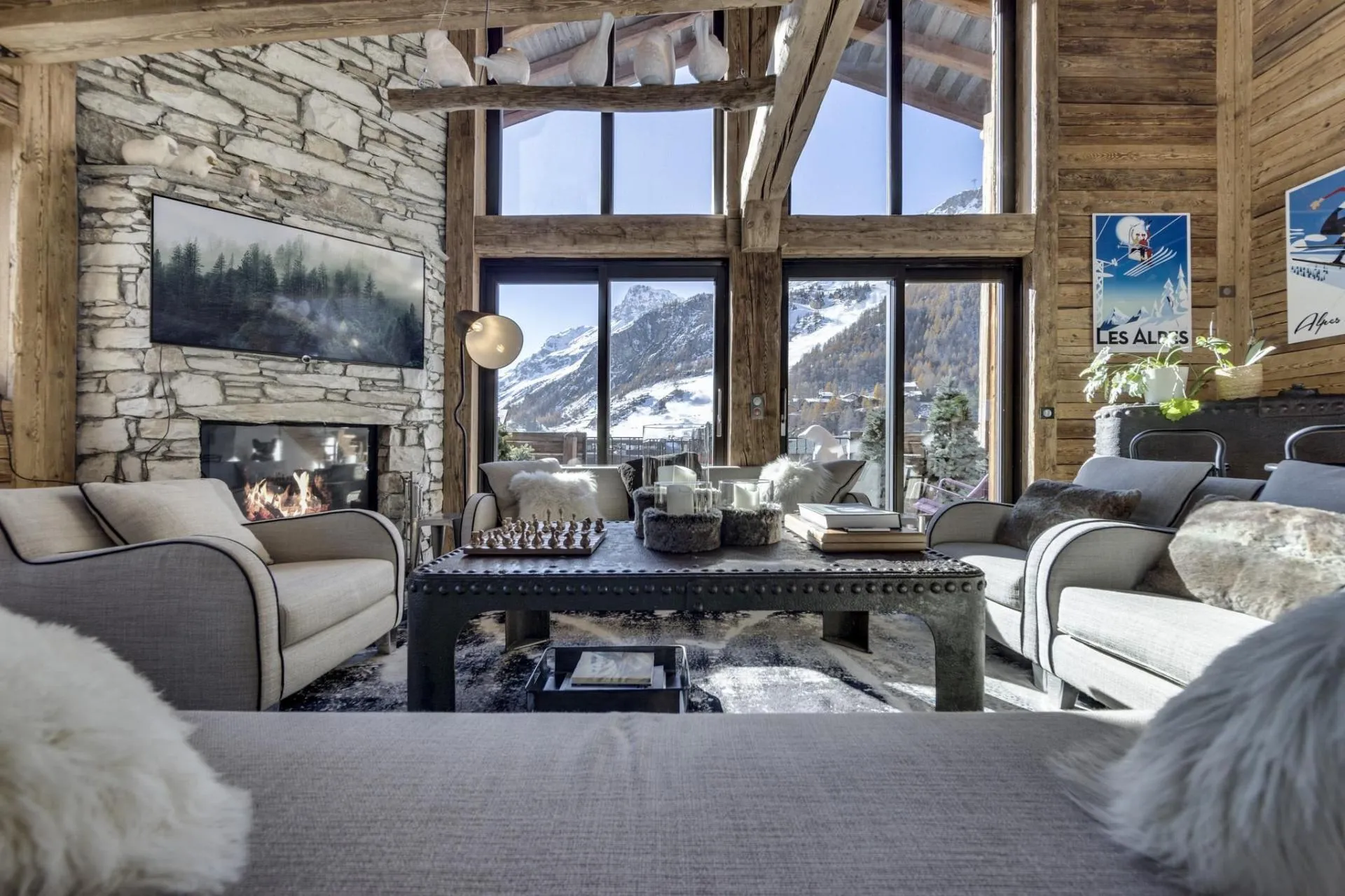 Open-plan living area with a stone fireplace and mountain views