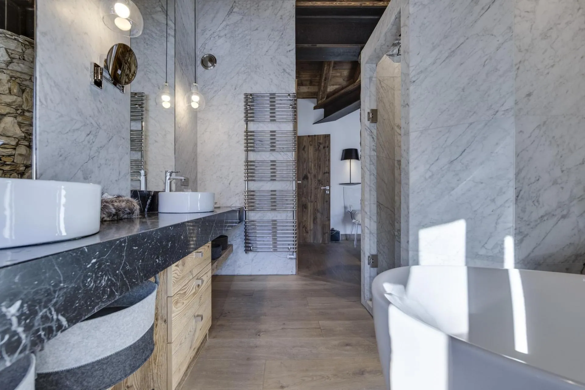 Bathroom with dual vessel sinks, heated towel rail, and walk-in shower